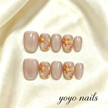 Faux ongles fleurs orange sur fond rose